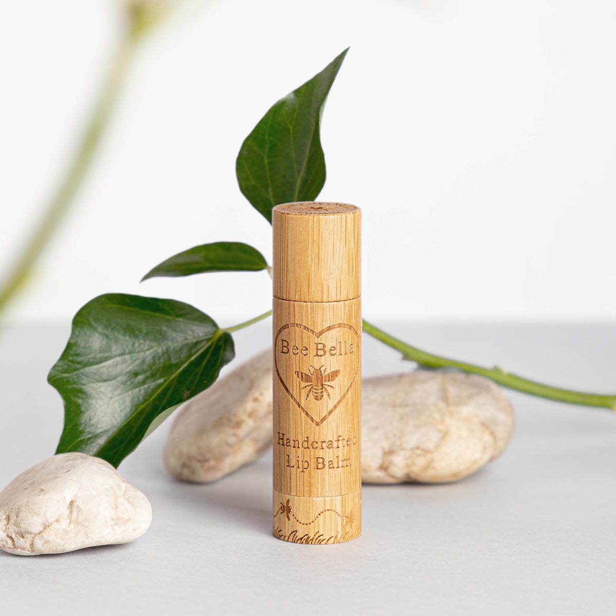 Lavender lip balm photographed with floating lavender flowers 5