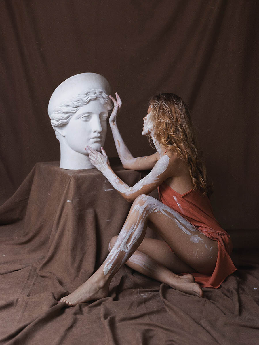 Model posing among colourful canvases during a creative portrait session 4