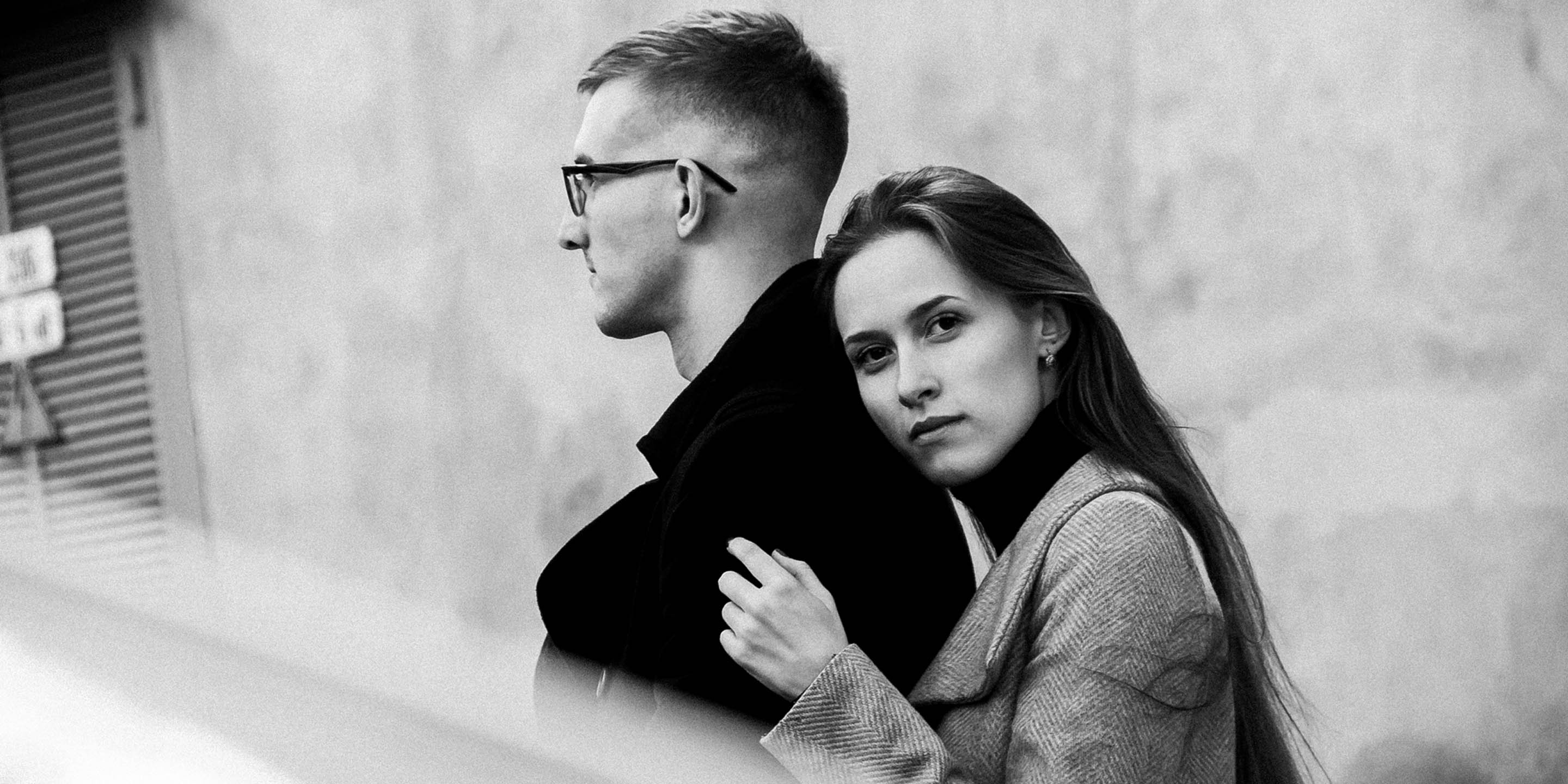 Black and white editorial portrait of a couple embracing in an urban setting 1