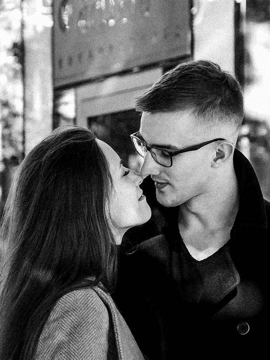 Black and white lifestyle portrait of a couple holding hands on a city street 7