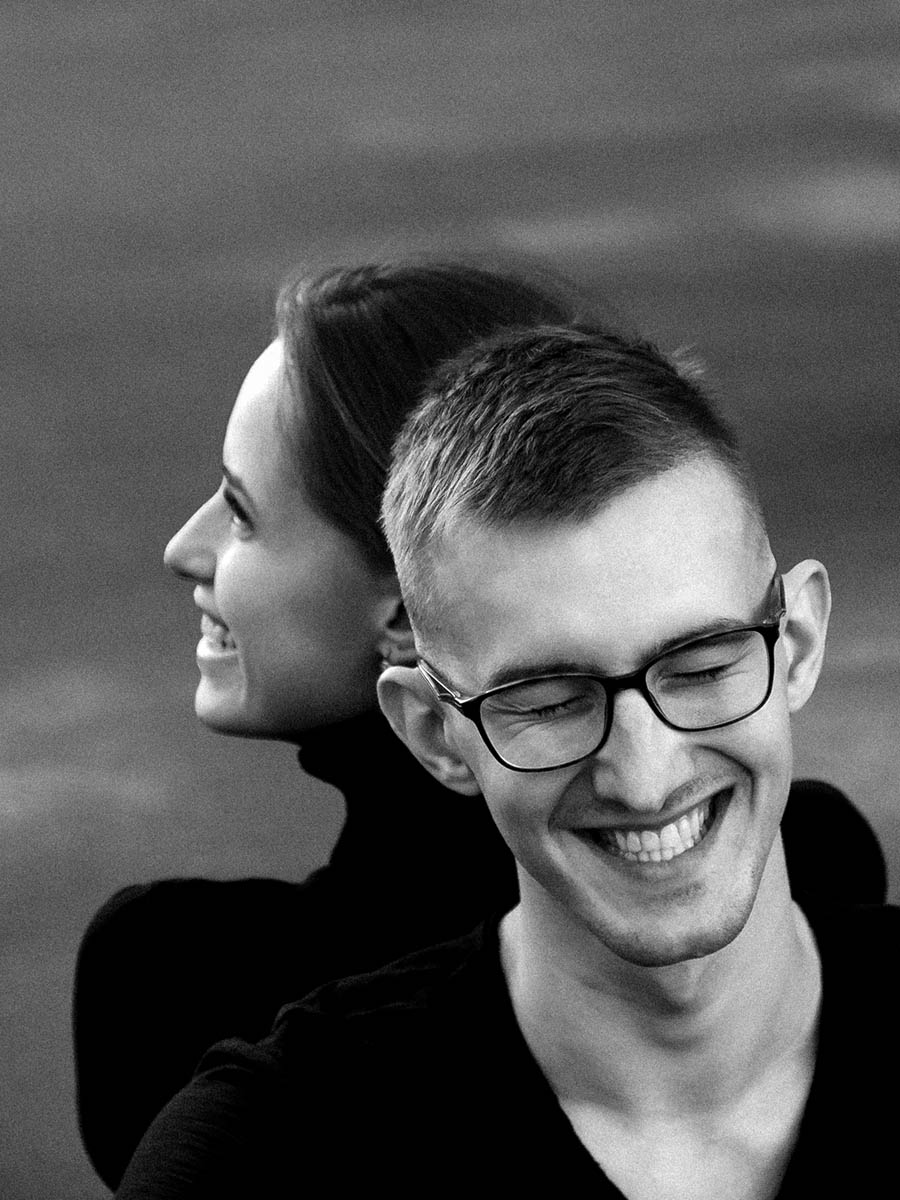 Black and white lifestyle portrait of a couple holding hands on a city street 17