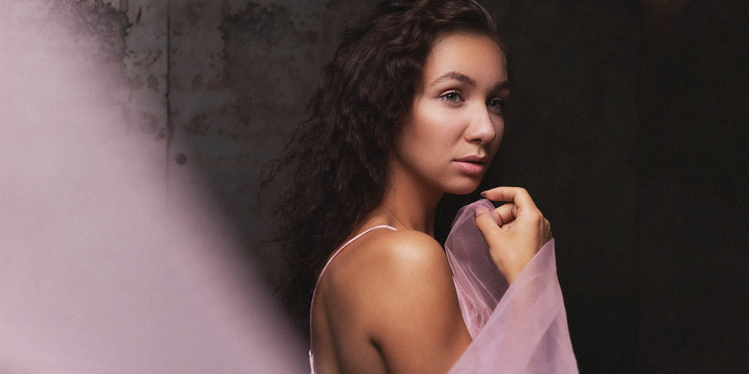 Editorial studio portrait with pink blossoms and soft pastel styling in Maastricht 1