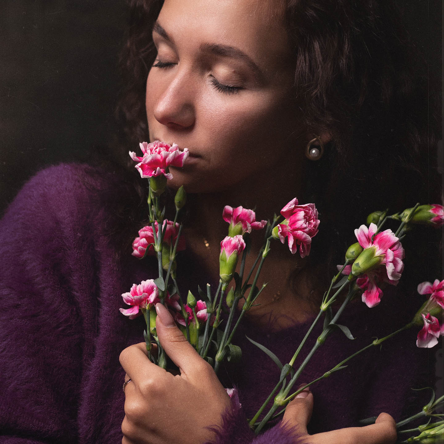 Close-up beauty portrait framed by delicate pink flowers in a studio 2